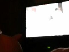 A cute MILF fingers her pussy while watching porn.