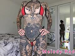 Closeup of Melody Radford's tattoos and big ass in thong bikini