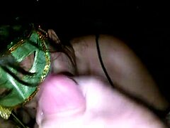 Milf in green mask passionately licks and sucks on a thick cock.
