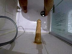 a big slave gets roughly fucked with bloody dildo in shower