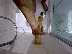 a big slave gets roughly fucked with bloody dildo in shower
