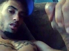 Tattooed woman masturbates suggestively in private scene.