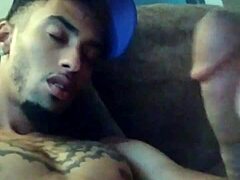 Tattooed woman masturbates suggestively in private scene.