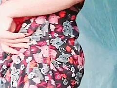 Sissy crossdresser in pink shirt and black mini skirt shows off white legs and big butt.