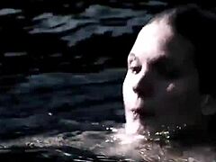 Beautiful blonde swims in the lake in a sexy bikini