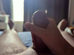 Solo amateur strokes monster cock in bedroom with sun rays shining through the window.