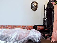 Wrapped in foil for total domination, her ass and face sitting under my boots in this BDSM humiliation session.