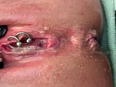 Why is this pierced clit getting rubbed hard in latex gloves before a strong pee stream?